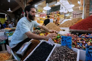 Một người bán hàng đang phân loại hàng hóa tại Chợ Lớn Tehran ở Iran, thứ Ba, ngày 25 tháng 8 năm 2026 [Vahid Salemi/AP]